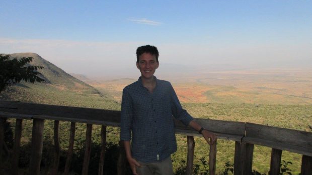 Image shows Matt Tyce, a PhD student secondee at the Open Innovation Team, with a view of the Rift Valley in Kenya behind him.